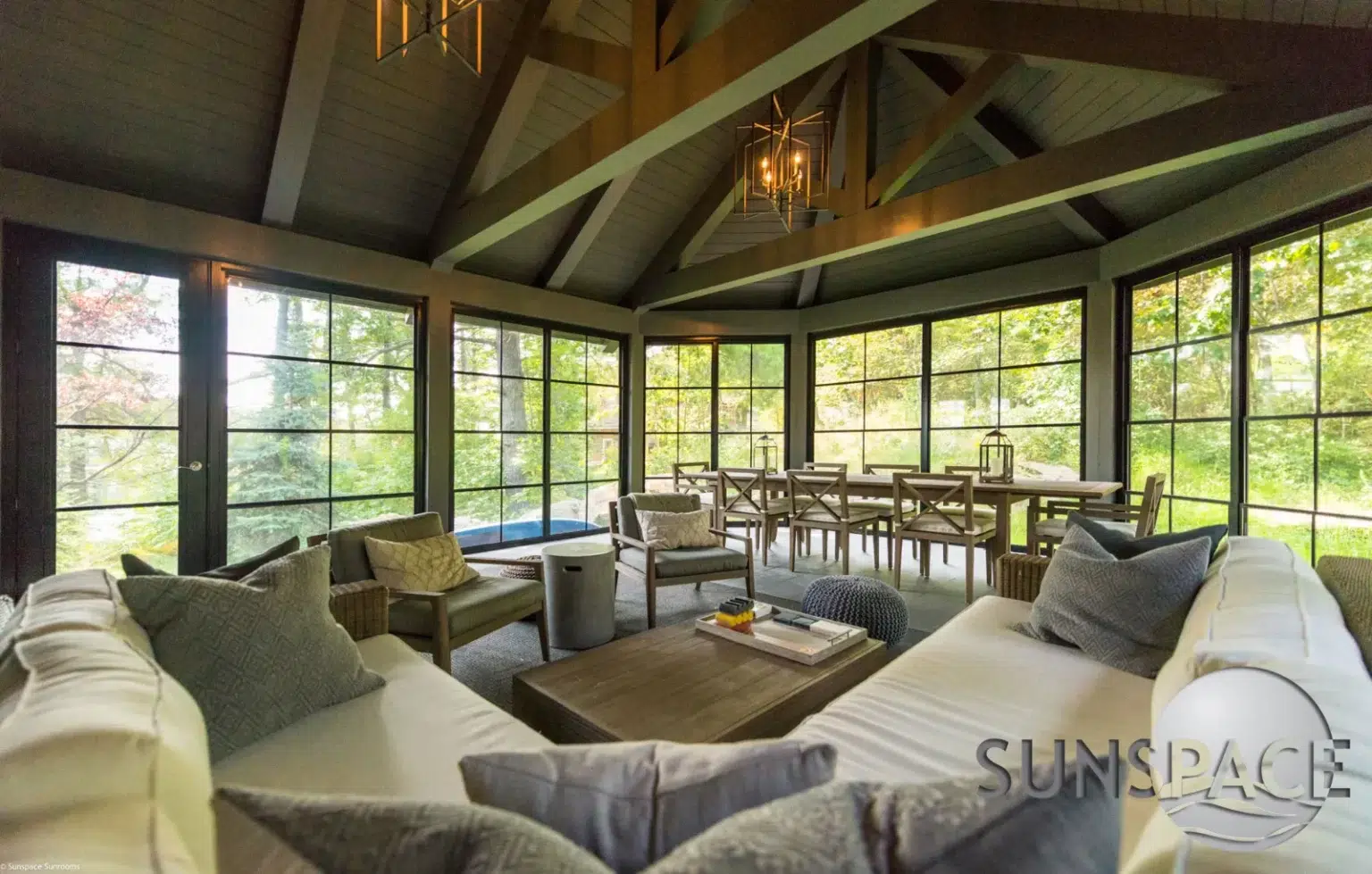 Sunroom with couches, table, and large windows