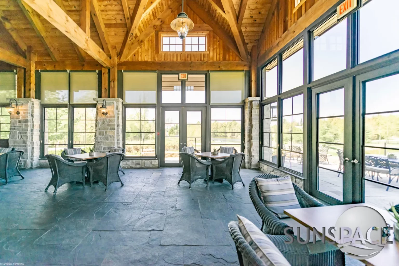 Rustic lodge dining room with wooden tables and mountain views.