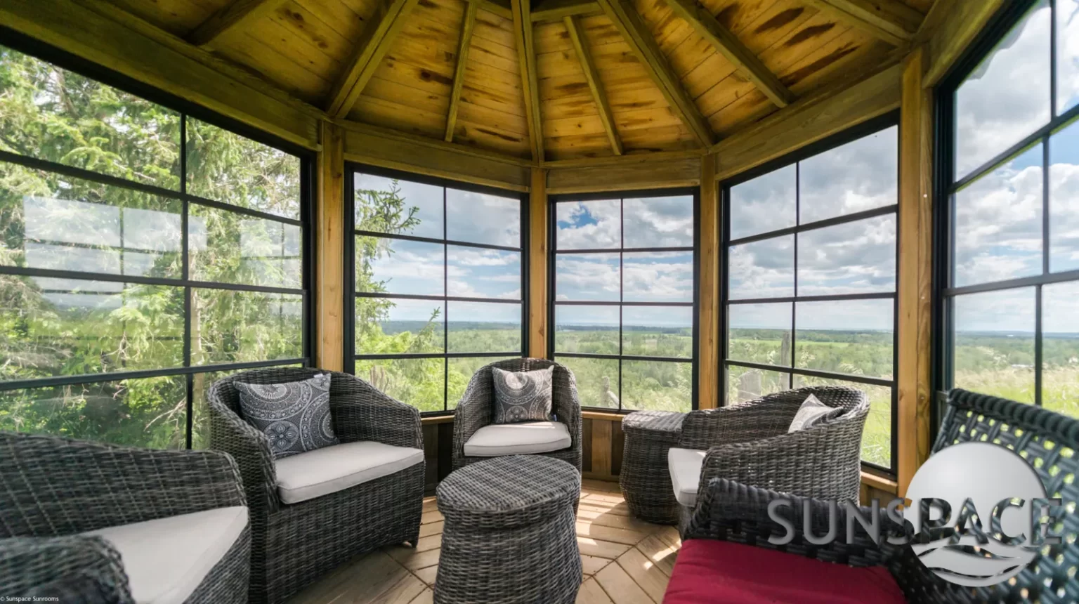 A Sunroom featuring wicker furniture, offering a scenic view of the mountains in the background.